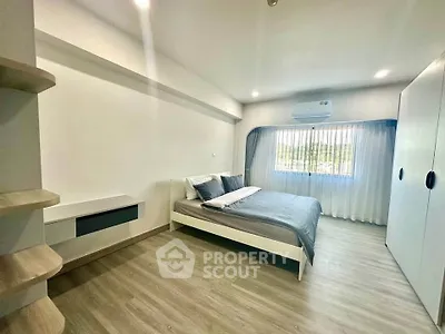 Spacious modern bedroom with large window and stylish decor