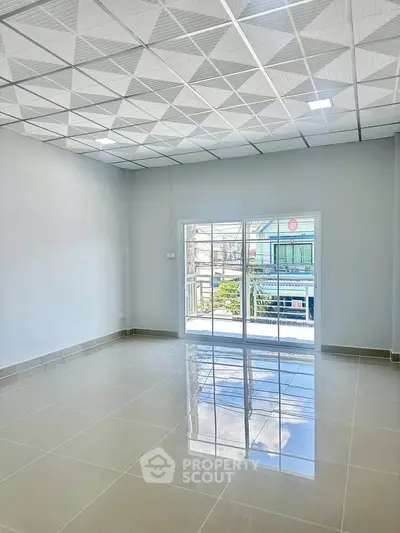 Spacious modern living room with glossy tiled floor and large sliding glass doors