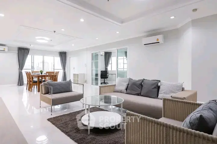 Spacious modern living room with elegant furniture and dining area, perfect for family gatherings.