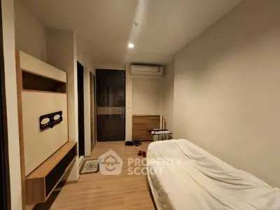 Cozy minimalist bedroom with wooden flooring and air conditioning