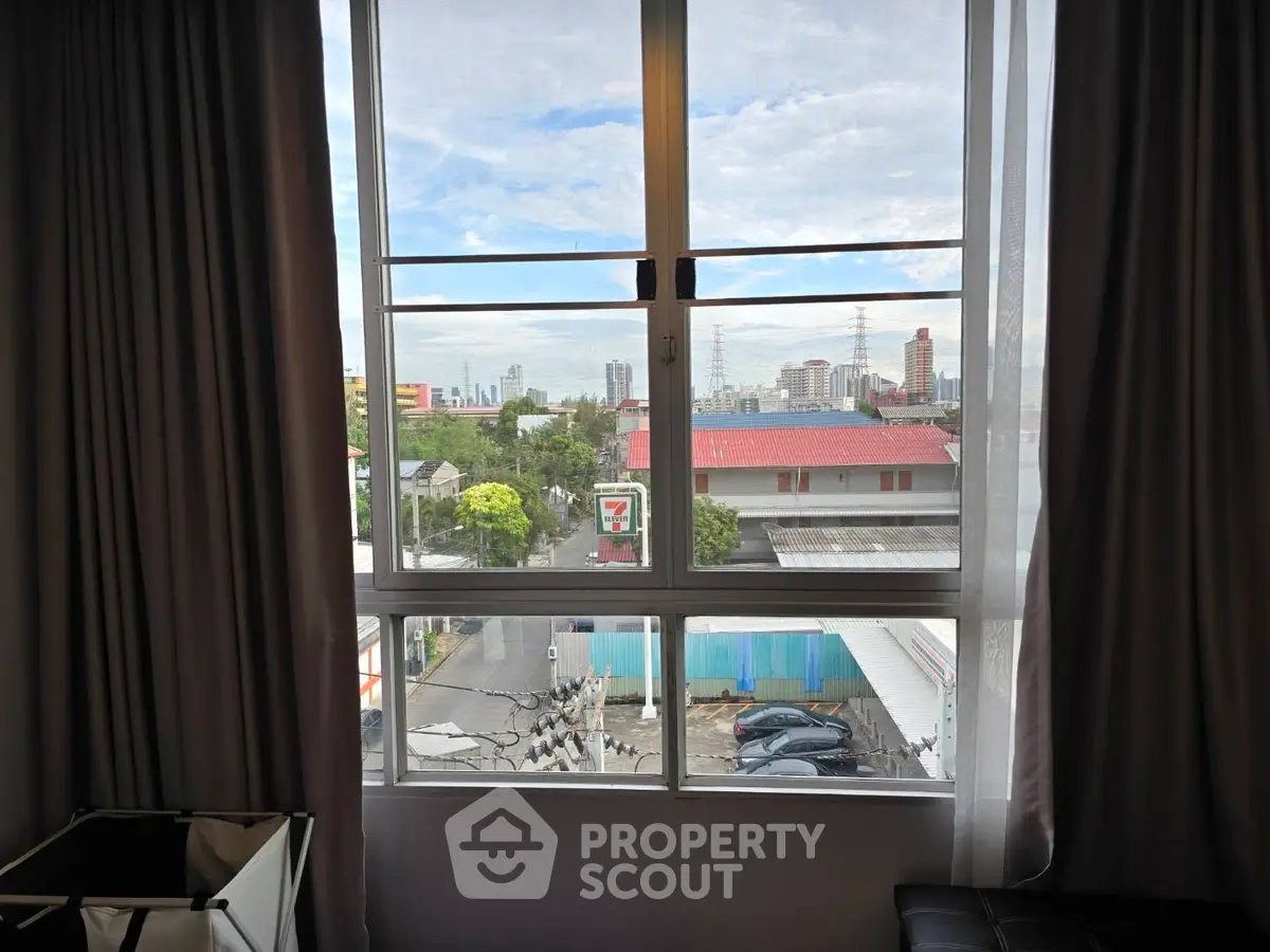 City view from apartment window with urban skyline and clear sky