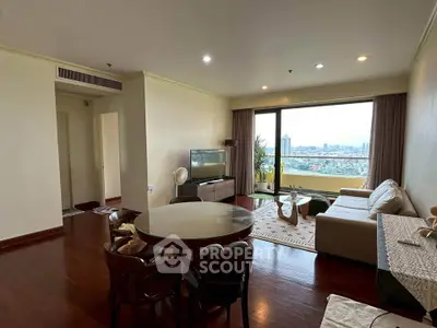 Spacious living room with city view, elegant furniture, and natural light in modern apartment.