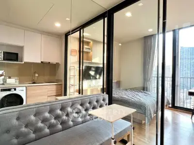 Modern apartment with glass partition, cozy living area, and stylish kitchen.