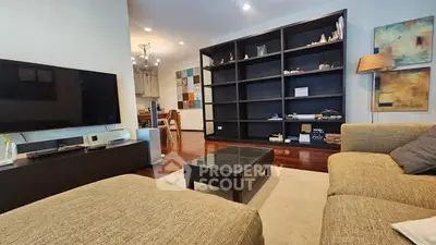 Spacious living room with modern decor and large TV, perfect for relaxation.