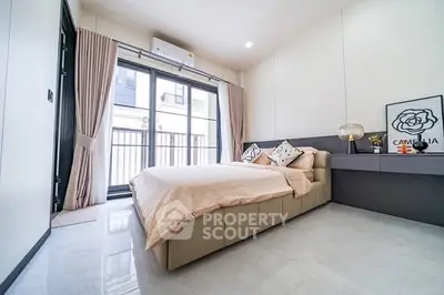 Modern bedroom with large windows and stylish decor in a contemporary apartment.