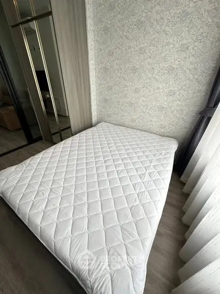 Cozy bedroom with minimalist decor and large window for natural light.