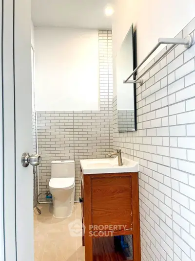 Modern bathroom with sleek white tiles and wooden vanity
