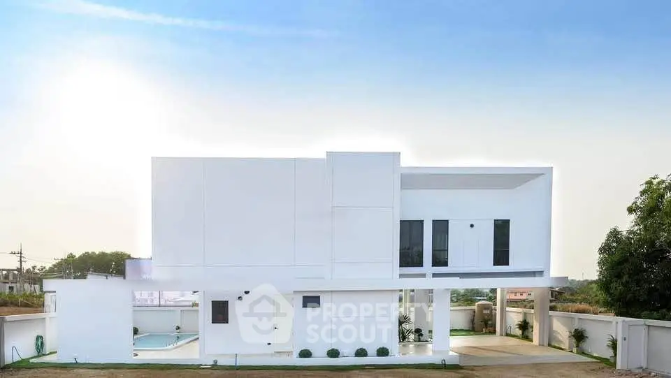 Modern minimalist white house with clean lines and spacious outdoor area, perfect for luxury living.
