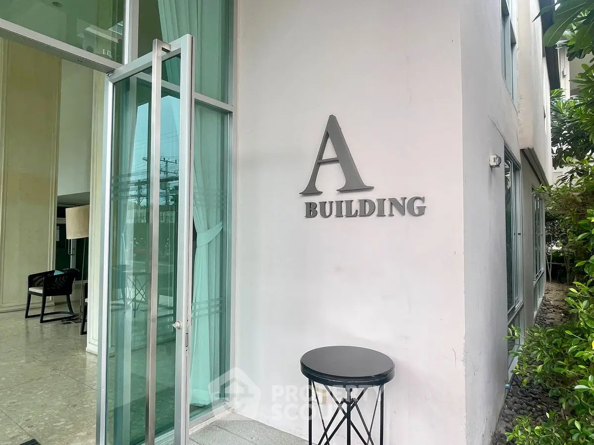 Modern building entrance with glass door and stylish signage