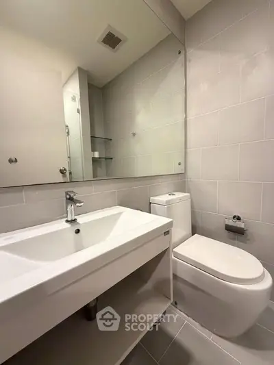 Modern bathroom with sleek fixtures and neutral tiles, perfect for a contemporary home.