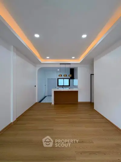 Modern open-plan living room with stylish lighting and wooden flooring