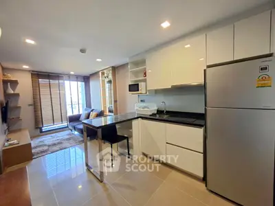 Modern open-layout kitchen and living room with sleek design and ample natural light.