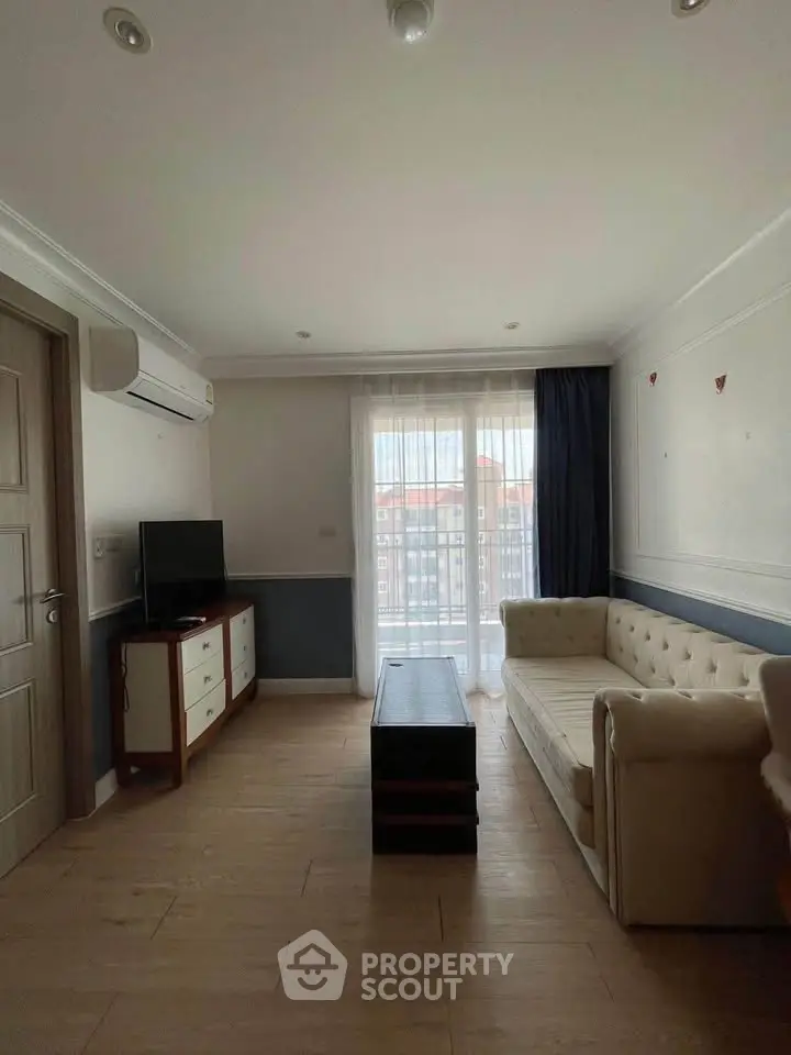 Cozy living room with elegant sofa and natural light from balcony view.