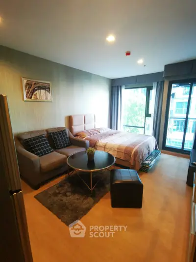 Modern studio apartment with cozy living area and large window view