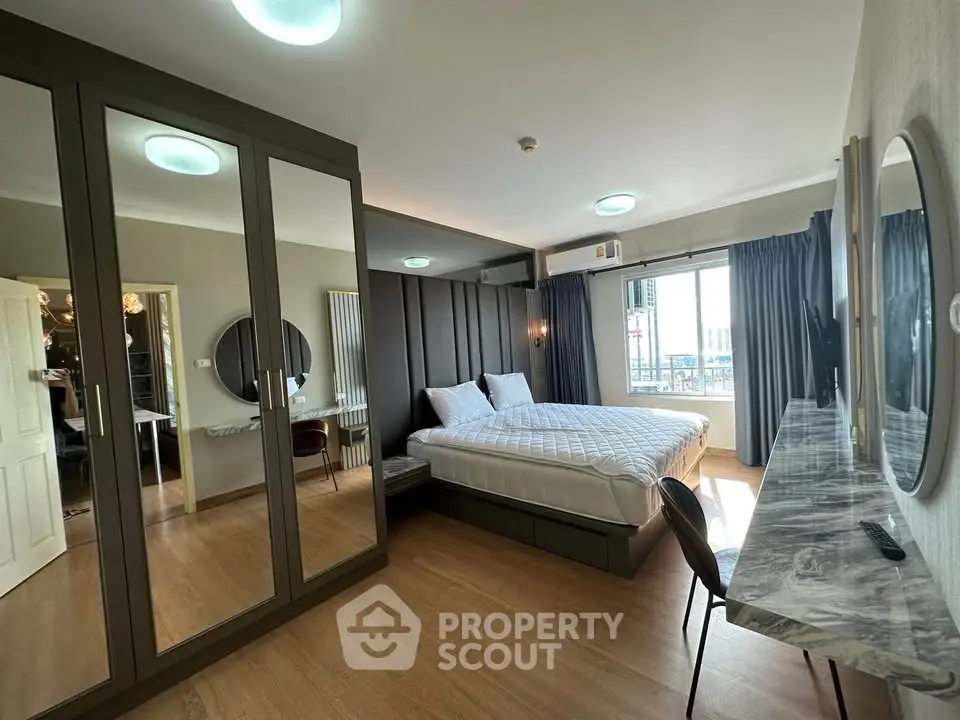 Spacious bedroom with mirrored wardrobe and elegant decor in modern apartment