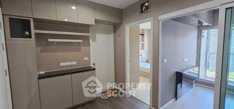 Modern apartment interior with sleek cabinetry and large windows offering natural light.