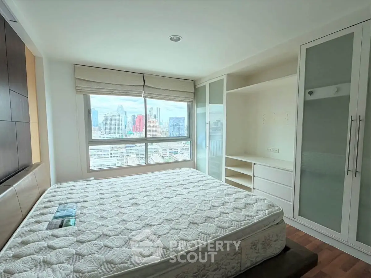Spacious bedroom with city view and built-in wardrobe in modern apartment