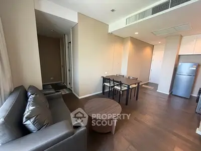 Modern living room with sleek furniture and dining area in open layout apartment.