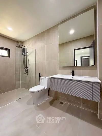 Modern bathroom with sleek fixtures and spacious shower in contemporary home.