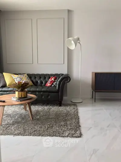 Stylish living room with leather sofa, modern decor, and chic floor lamp.