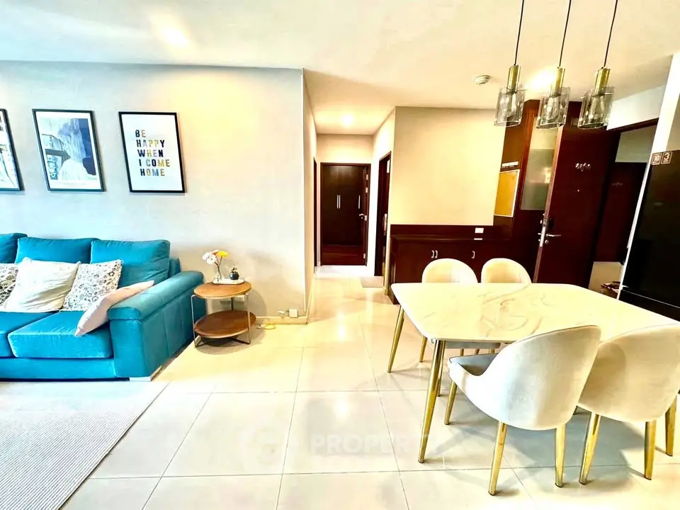 Modern living room with blue sofa and elegant dining area in open layout apartment.