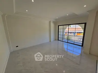 Spacious unfurnished room with large windows and balcony view