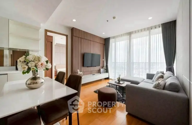 Modern living room with elegant decor and large windows offering natural light.