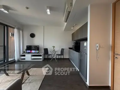 Modern open-plan living room with sleek kitchen and balcony access