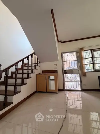 Spacious interior with elegant staircase and natural light, perfect for modern living.