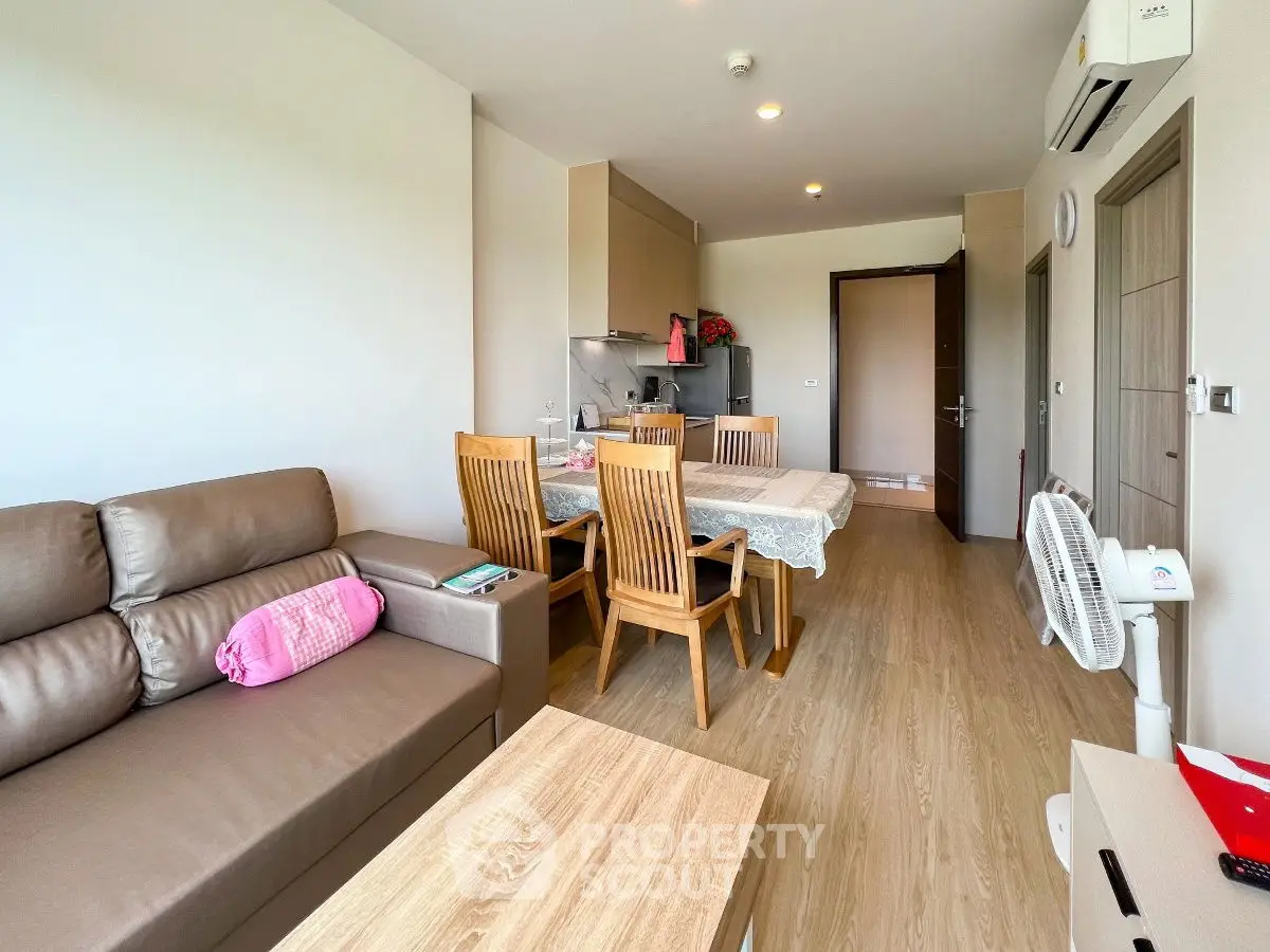 Modern living room with dining area and open kitchen in a cozy apartment.