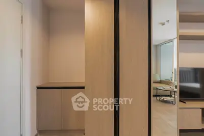 Modern apartment interior with sleek wooden cabinetry and open living space.