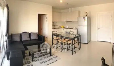 Modern open-plan living room and kitchen with sleek furniture and natural light.