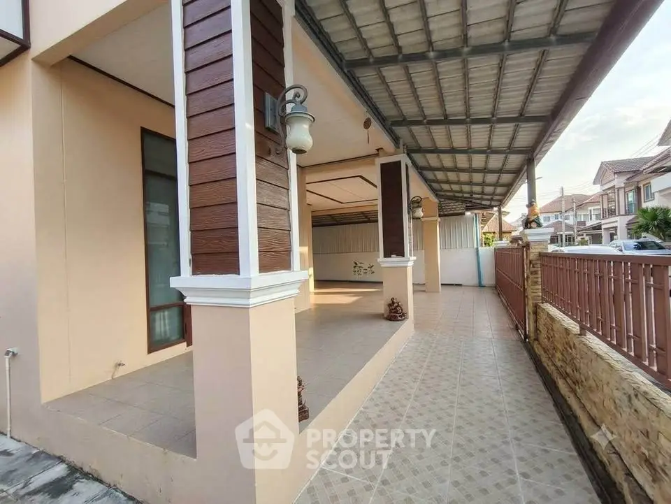 Spacious covered patio with elegant lighting and tiled flooring in a modern residential area.