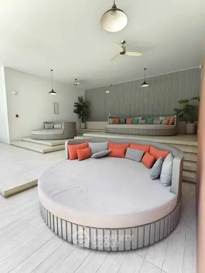 Luxurious modern living area with stylish round seating and vibrant cushions, perfect for relaxation.
