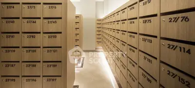 Modern apartment building mailroom with sleek wooden mailboxes and ambient lighting.