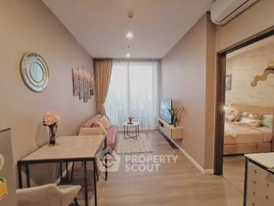 Modern living room with stylish decor and open layout, featuring a cozy seating area and wall-mounted TV.