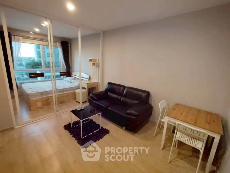 Modern studio apartment with glass partition, cozy living area, and stylish bedroom.