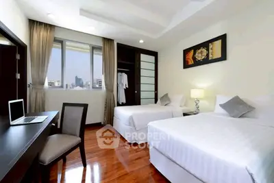Spacious bedroom with twin beds, modern decor, and city view, ideal for comfort and relaxation.