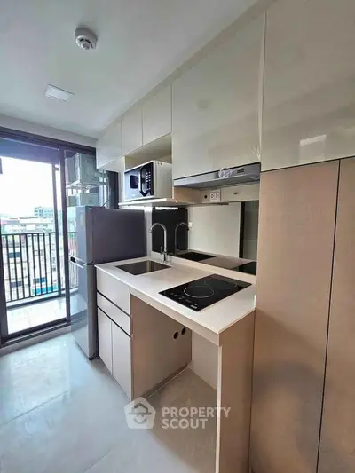 Modern kitchen with sleek cabinetry and balcony view in a stylish apartment