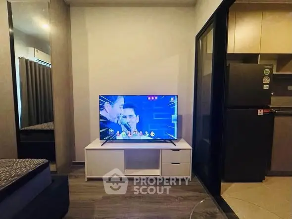 Modern living room with TV and kitchen area in compact apartment