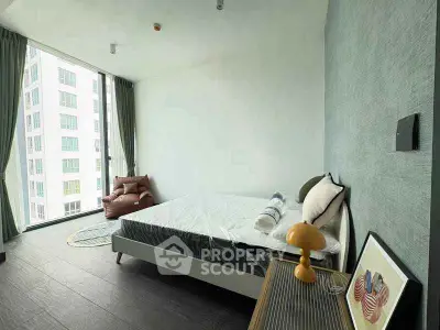 Modern bedroom with large window and stylish decor in high-rise apartment.