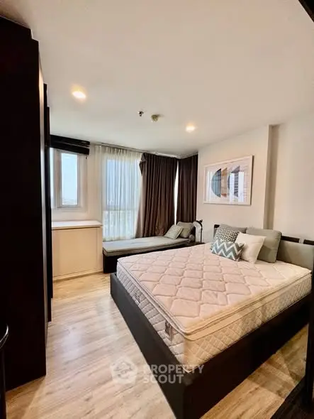 Modern bedroom with stylish decor and natural light, featuring a comfortable bed and chic furnishings.