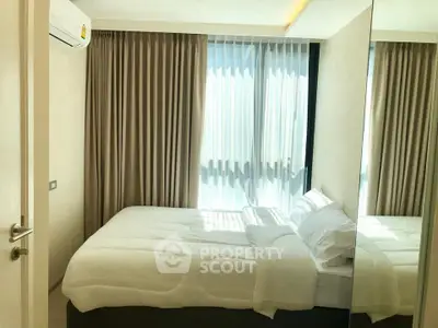 Cozy bedroom with natural light and modern decor, featuring a comfortable bed and elegant curtains.