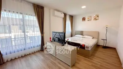 Spacious bedroom with modern decor and large windows for natural light