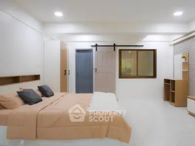 Spacious modern bedroom with minimalist design and ample natural light.