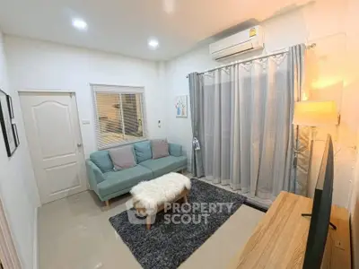 Cozy living room with modern decor, featuring a plush sofa, stylish rug, and ambient lighting.