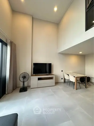 Spacious modern living room with high ceiling and elegant dining area