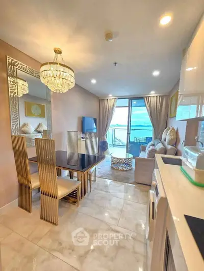 Luxurious open-plan living room with ocean view, elegant dining area, and modern kitchen appliances.