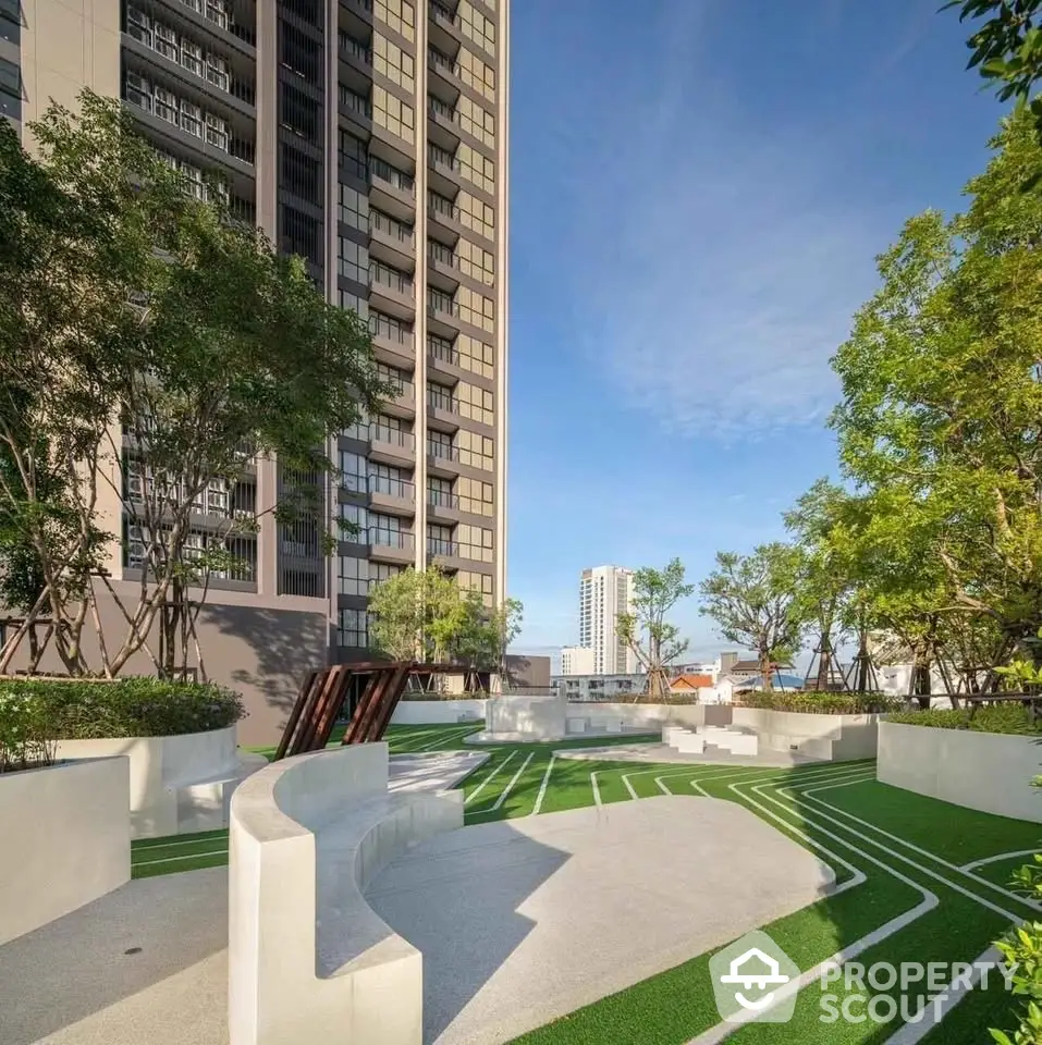 Modern high-rise building with landscaped garden and seating area