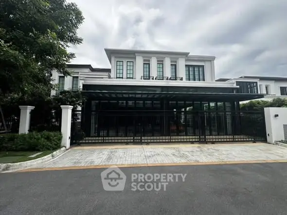 Elegant modern house with spacious driveway and lush greenery, perfect for luxurious living.